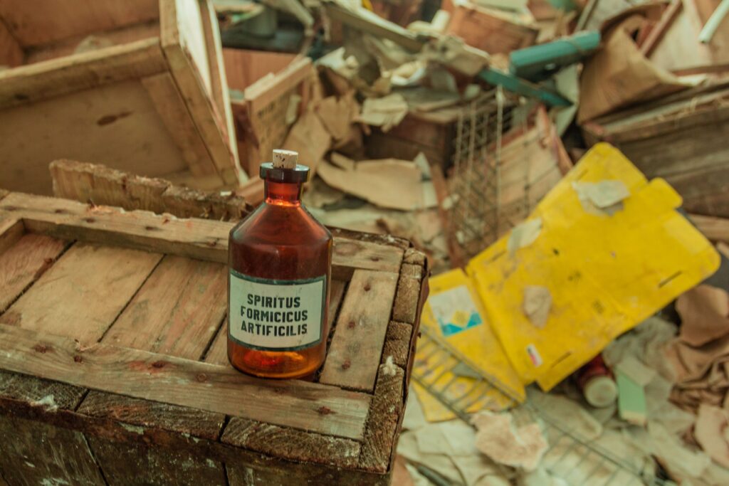 A vintage glass bottle sits amidst disorganized storage crates and scattered debris.